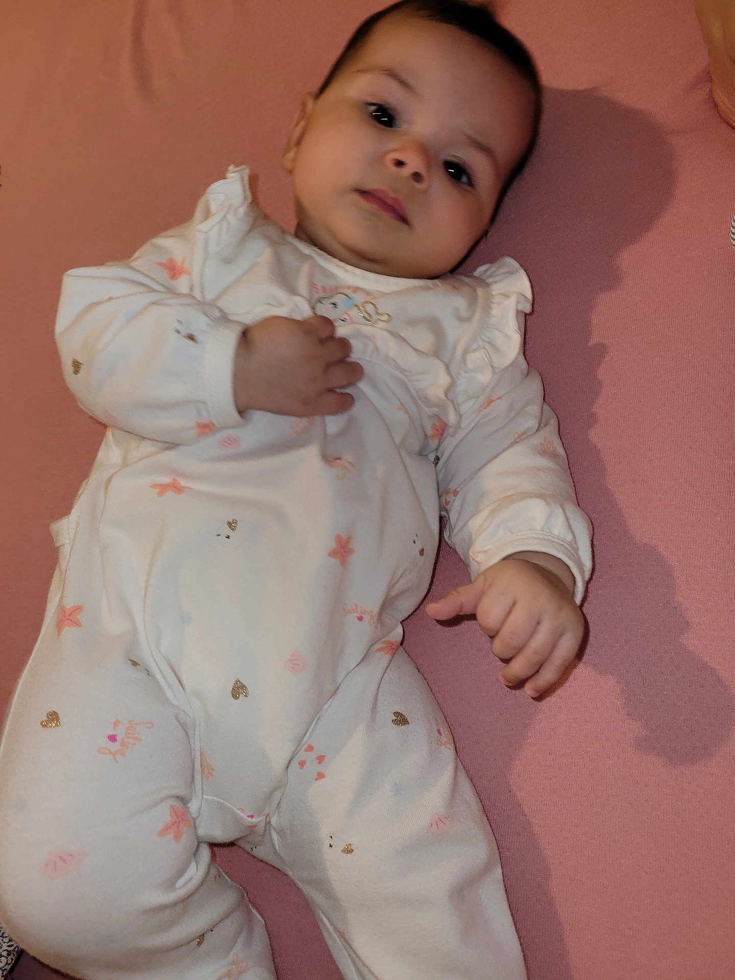 Sirine participe au concours pour gagner de l'argent avec cette photo : baby, infant, onesie, pink_background, lying_down, face, hand, cute, calm, child, newborn, soft_lighting, shadow, clothing, sleepwear, portrait, young_child, indoor, person, skin