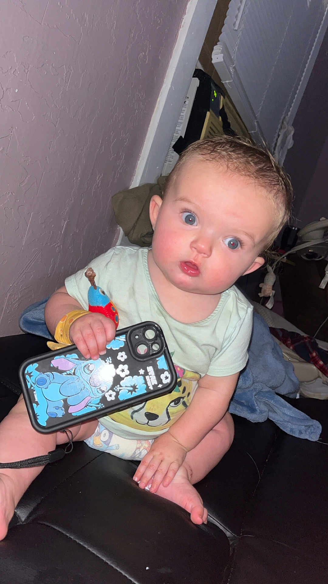 Charlotte joined the competition — help win amazing prizes! baby, infant, blue_eyes, phone_case, stitch, sitting, indoor, couch, curious, clothing, diaper, hand, foot, wall, toy, blanket, person, face, child, expression