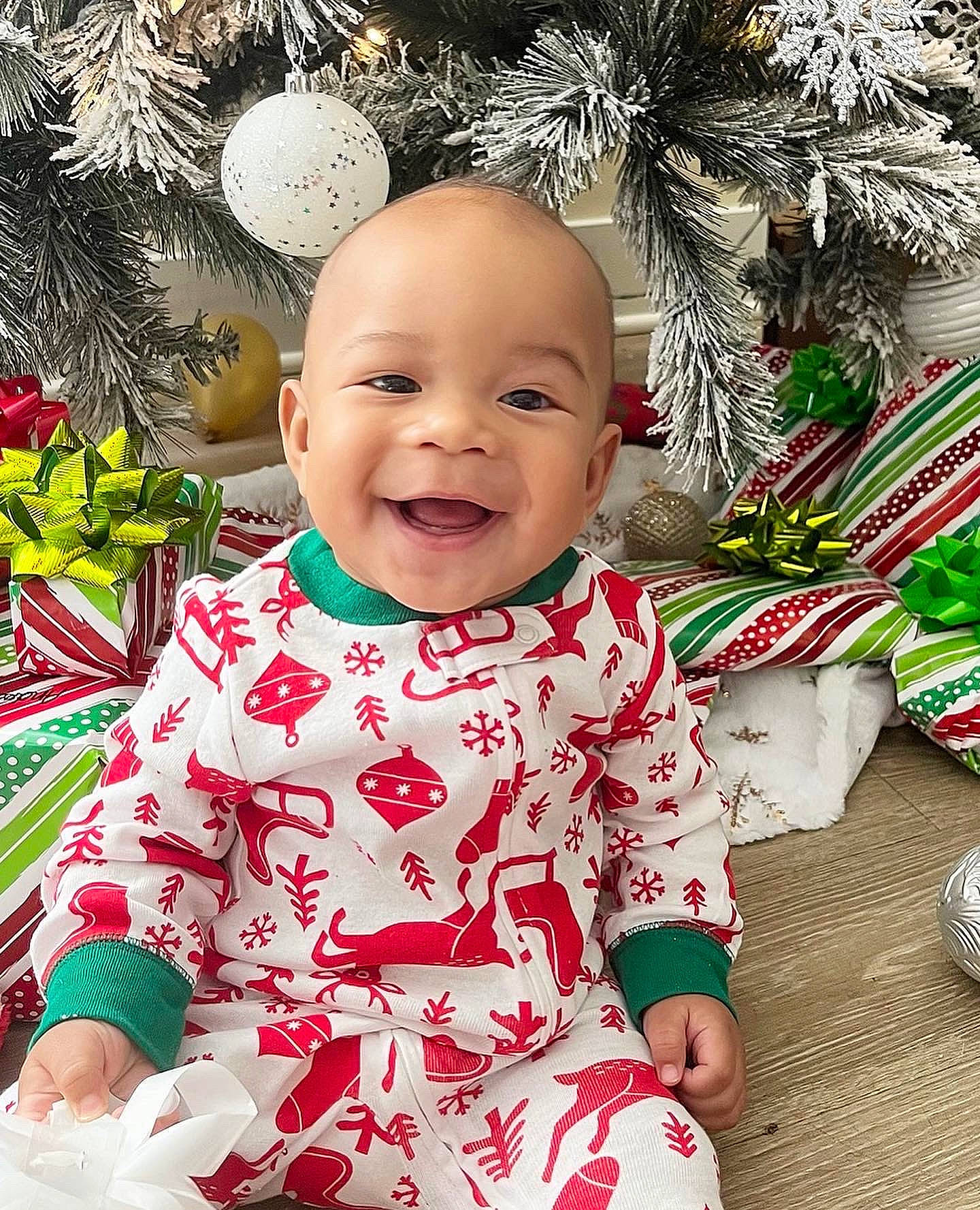 Lennox is registered to the contest to win money with this photo: baby, baby_toddler_clothing, cheek, christmas_ornament, eye, face, facial_expression, fun, grass, happy, head, joy, people_in_nature, person, photograph, red, skin, sleeve, smile, snapshot
