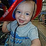 child, toddler, smiling, blue_eyes, cowboy_hat, shopping_cart, store, aisle, clothing, short_sleeve_shirt, happy, person, retail, indoor, baby, cute, face, hat, playing, closeup