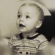 Declan is registered to the contest to win money with this photo: child, toddler, portrait, sepia, striped_clothing, cute, baby, face, expression, looking_up, indoors, young, head, person, zipped_outfit, button, round_frame, soft_light, close_up, curious