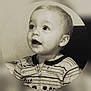 child, toddler, portrait, sepia, striped_clothing, cute, baby, face, expression, looking_up, indoors, young, head, person, zipped_outfit, button, round_frame, soft_light, close_up, curious