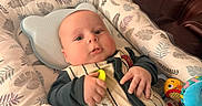 Lucas joined the competition — help win amazing prizes! baby, infant, child, toy, plush_toy, cushion, blanket, pattern, leaf_pattern, comfort, indoor, closeup, cute, face, hand, clothing, resting, soft, colorful, expression