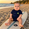 Lucas is registered to the contest to win money with this photo: baby, beach, surfboard, sand, ocean, sunset, child, coast, waves, blue_clothing, palm_tree, foot, hand, sky, outdoor, nature, person, vacation, summer, cute