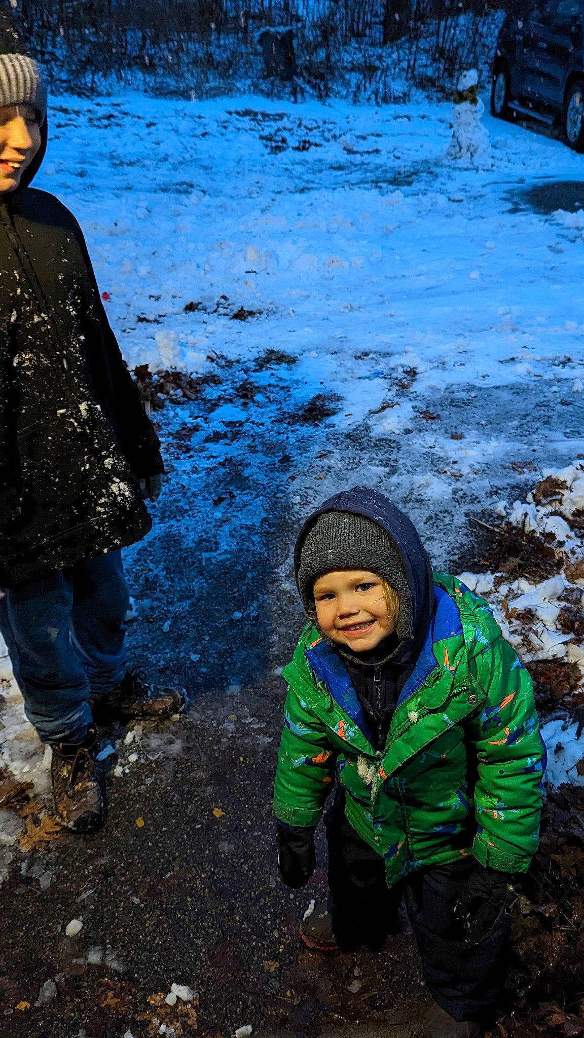 Brycen is registered to the contest to win money with this photo: body_of_water, child, freezing, fun, geological_phenomenon, grass, happy, headwear, jacket, joy, landscape, leisure, outerwear, people_in_nature, person, smile, snow, standing, tire, toddler