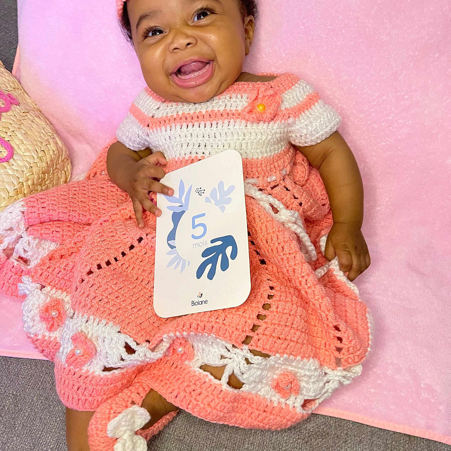 Maylee a rejoint le concours — aidez-le/la à gagner de superbes lots ! age_card, baby, blanket, card, celebration, child, crochet_dress, cute, footwear, happy, headband, holding, indoor, infant, pink, portrait, sitting, smiling, soft_texture, white