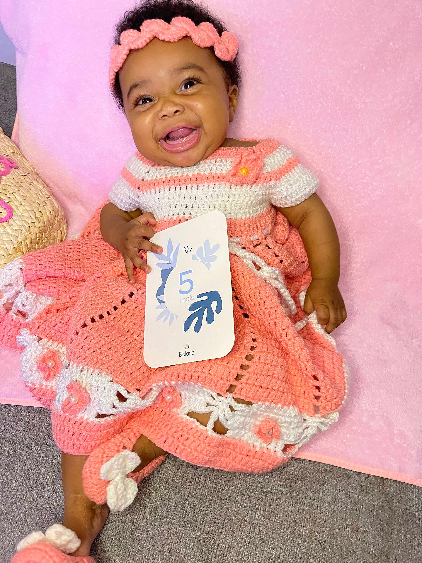 Maylee a rejoint le concours — aidez-le/la à gagner de superbes lots ! baby, child, crochet_dress, headband, pink, white, smiling, happy, card, holding, blanket, indoor, cute, infant, soft_texture, footwear, sitting, portrait, celebration, age_card