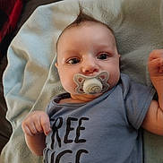 Michael joined the competition — help win amazing prizes! baby, baby_girl_or_boy, blanket, blue_shirt, child, clothing, cute, face, hand, human, indoor, infant, lying_down, mohawk_hairstyle, pacifier, portrait, smiling_eyes, soft_fabric, text_on_clothing, young