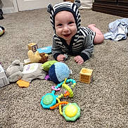 Michael joined the competition — help win amazing prizes! baby, child, carpet, toy, block, smile, hoodie, striped_clothing, indoor, floor, playtime, cute, person, infant, colorful, happy, baby_toys, furniture, door, room
