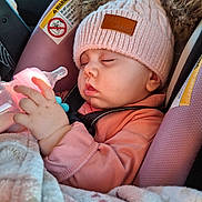 Skyler is registered to the contest to win money with this photo: baby, infant, sleeping, car_seat, knit_hat, pom_poms, feeding_bottle, hand, blanket, seatbelt, car_interior, safety_warning_label, pink_clothing, chubby_cheeks, closed_eyes, adorable, cozy, profile, soft_texture, pacifier_clip