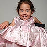 Leslie joined the competition — help win amazing prizes! child, girl, portrait, smiling, happy, dress, pink_dress, floral_pattern, hair_buns, sitting, chair, indoor, studio, gray_background, fashion, formal_wear, tulle, childhood, teeth, face
