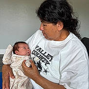 Sophia joined the competition — help win amazing prizes! baby, newborn, infant, caregiver, woman, holding, portrait, indoor, seated, cuddling, family, love, smiling, white_shirt, floral_outfit, blanket, chair, dark_hair, close_up, safe