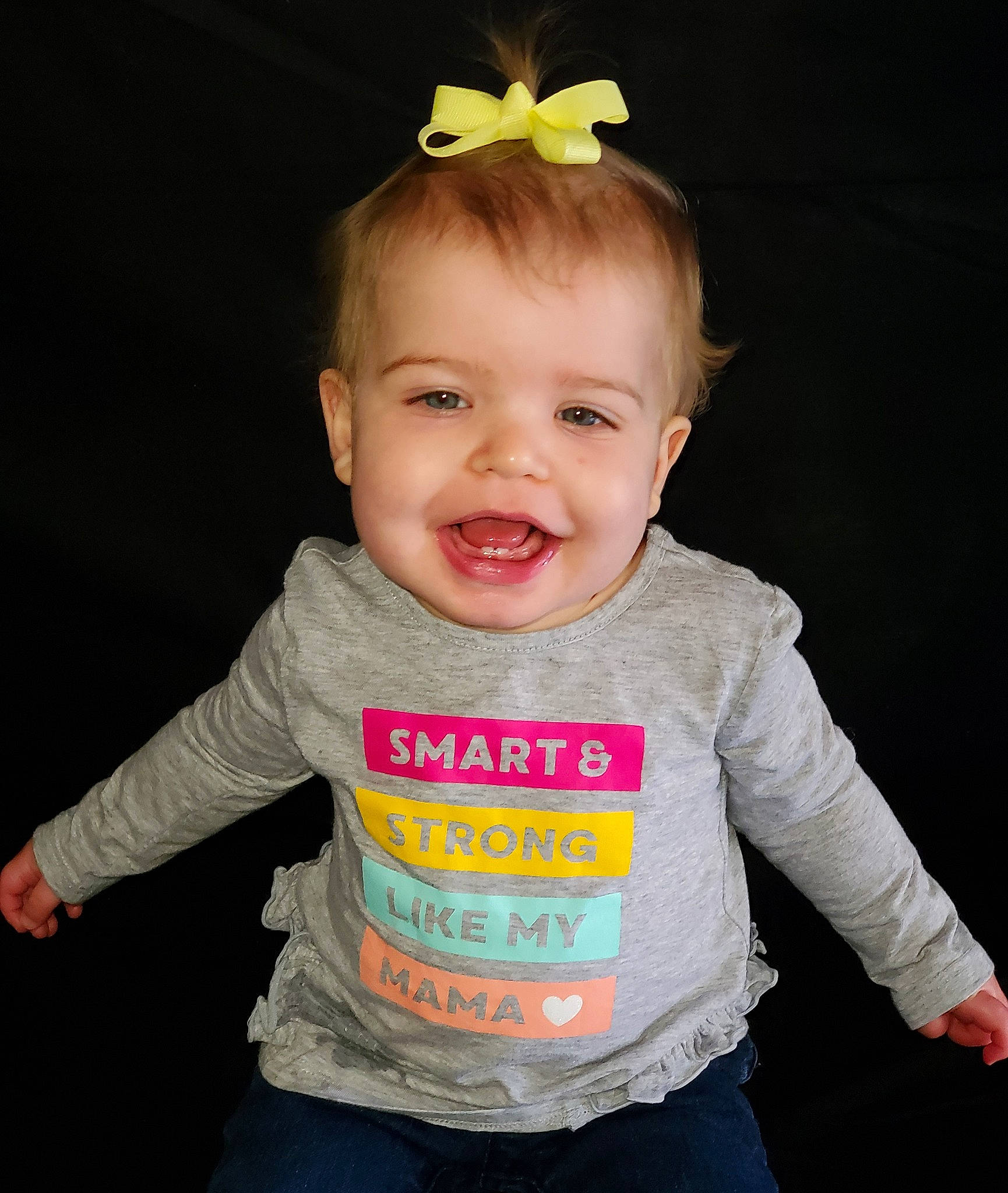 Eliana is registered to the contest to win money with this photo: baby, baby_toddler_clothing, child, child_model, ear, face, facial_expression, hair_accessory, happy, head, neck, organ, person, product, sleeve, smile, t_shirt, toddler, top, yellow