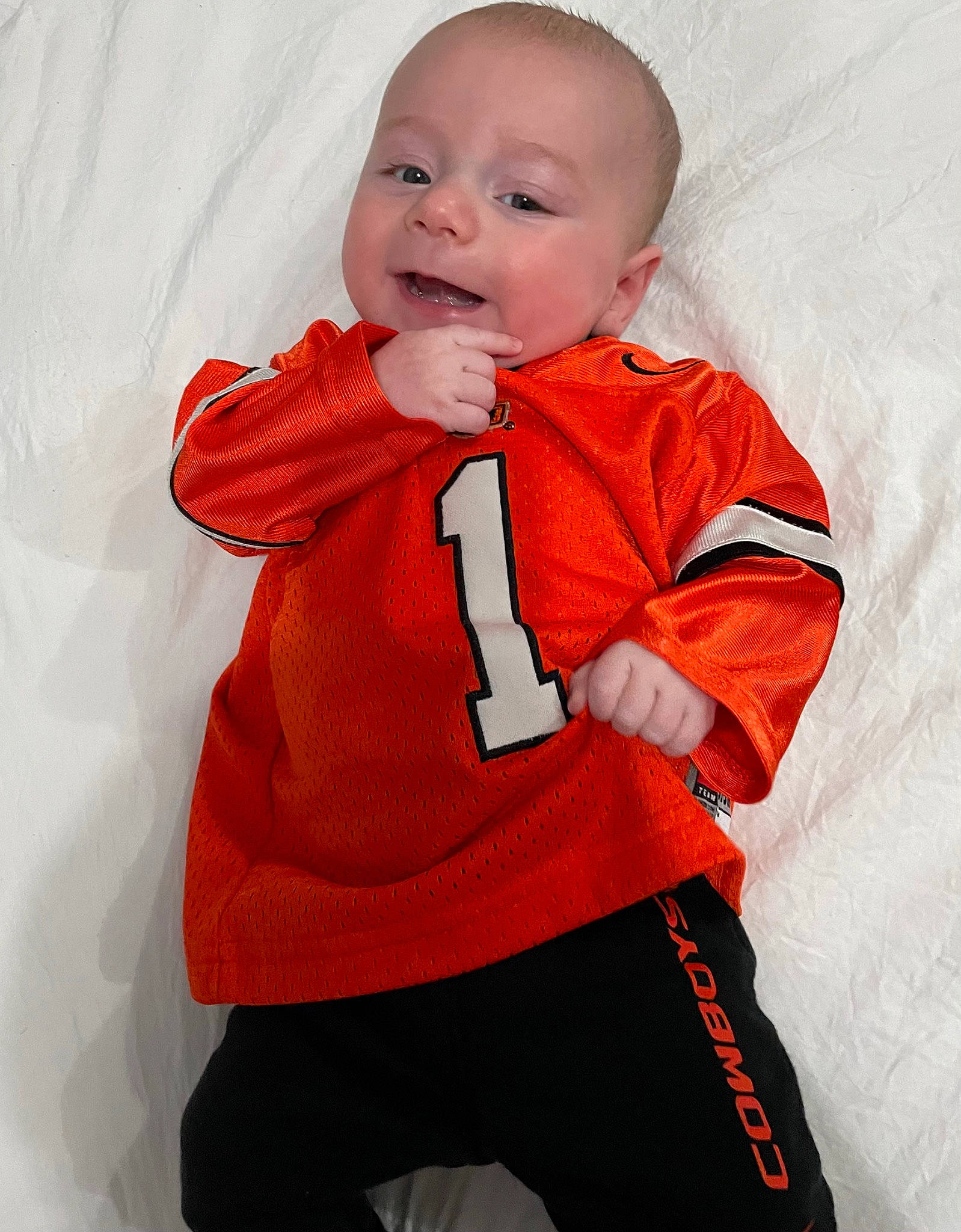 Stoney is registered to the contest to win money with this photo: baby, baby_toddler_clothing, cheek, child, collar, eye, face, fun, happy, iris, jacket, nose, orange, pattern, person, sleeve, smile, sportswear, t_shirt, textile