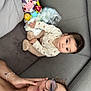 Eliott participe au concours pour gagner de l'argent avec cette photo : baby, woman, glasses, couch, toy, plush_toy, diaper, cushion, face, person, indoor, relaxed, casual, clothing, infant, smile, home, comfort, child, resting