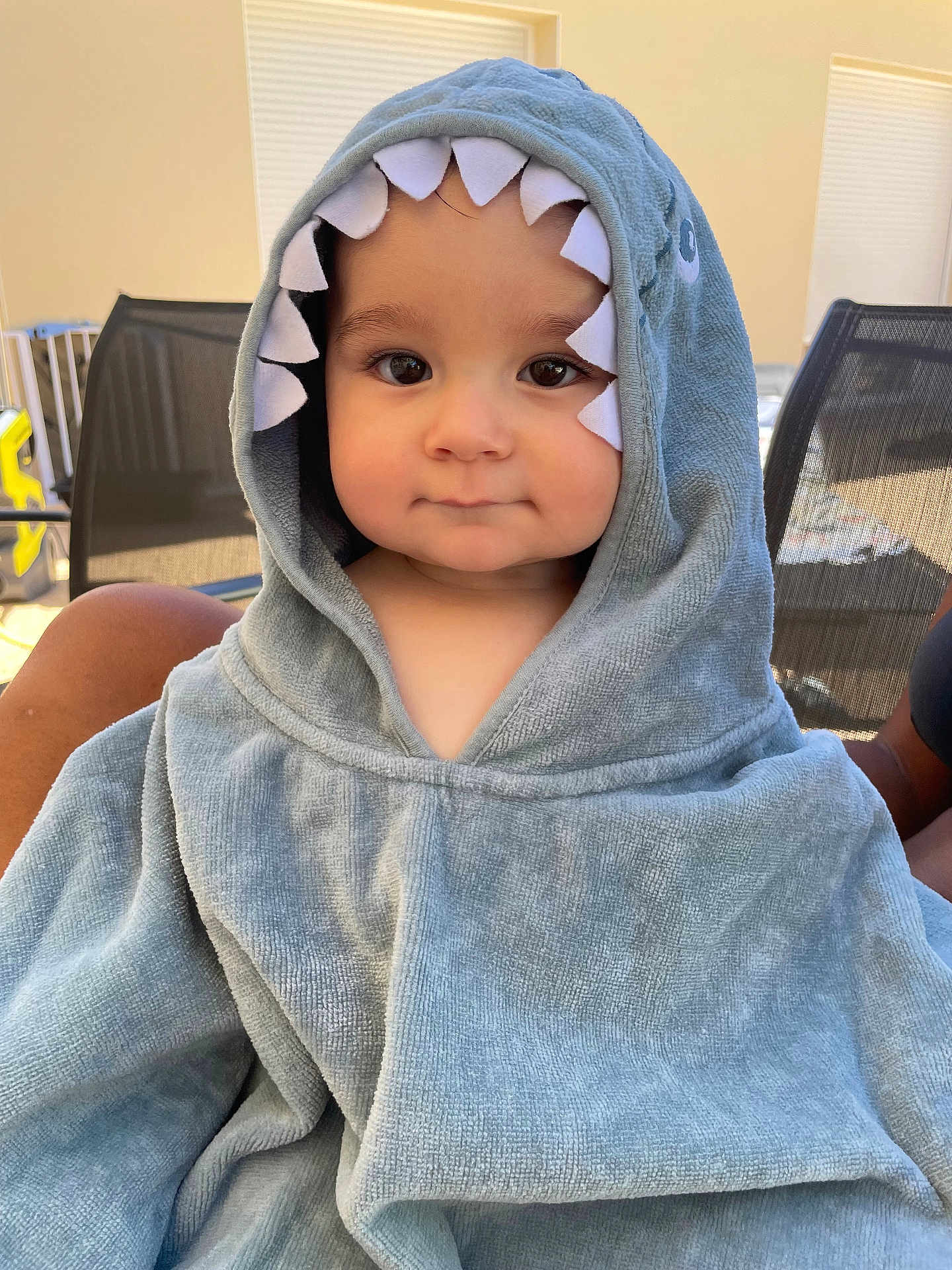 Eliott a rejoint le concours — aidez-le/la à gagner de superbes lots ! baby, blanket, chair, child, cozy, cute, daylight, eyes, face, furniture, headwear, hooded_towel, outdoor, patio, person, shark_costume, skin, smile, soft_texture, toddler
