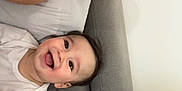 Eliott participe au concours pour gagner de l'argent avec cette photo : baby, woman, glasses, smile, couch, plush_pillow, happy, face, relaxing, indoor, casual, joyful, portrait, child, person, home, furniture, clothing, skin, expression