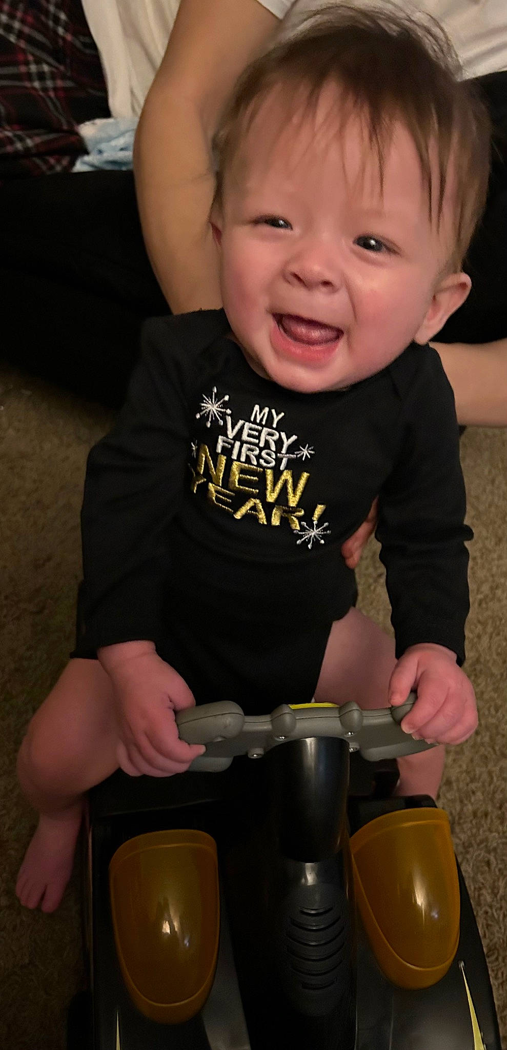 Kai is registered to the contest to win money with this photo: baby, baby_toddler_clothing, cheek, drinkware, elbow, fun, happy, human_leg, knee, neck, person, personal_protective_equipment, sitting, skin, sleeve, smile, t_shirt, thigh, thumb, toddler