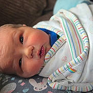 Cillian joined the competition — help win amazing prizes! newborn, baby, infant, wrapped, blanket, striped, face, eyes, cushion, pattern, bunny, flower, resting, close_up, soft, cute, indoors, child, person, sleepy