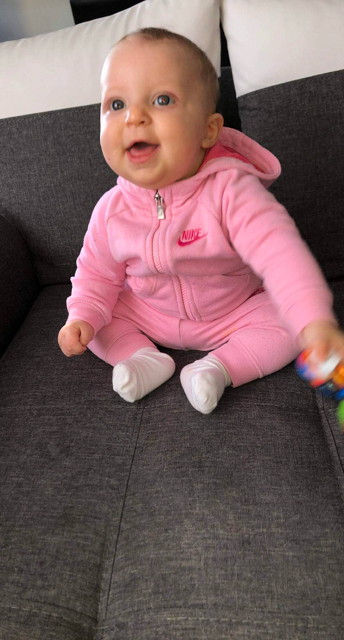 Yasmine a rejoint le concours — aidez-le/la à gagner de superbes lots ! baby, baby_toddler_clothing, cheek, child, comfort, couch, finger, floor, flooring, foot, living_room, mouth, person, sitting, skin, sock, sofa_bed, toddler, tongue