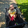 Lillith is registered to the contest to win money with this photo: baby, stroller, sidewalk, grass, toy, rubber_duck, bottle, headband, onesie, sunlight, shadow, outdoor, happy, smiling, child, person, summer, play, colorful, nature