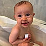 baby, bathtub, bath, child, water, wet, skin, hand, container, sponge, smile, face, eyes, head, indoors, person, tile, bathroom, cute, young