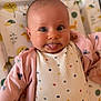 Nicole is registered to the contest to win money with this photo: baby, infant, tongue_out, polka_dot, onesie, pink_jacket, cute, playful, animal_pattern, blanket, lying_down, cheeky, expression, child, face, eyes, soft_lighting, indoors, smile, portrait