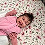 Ivory is registered to the contest to win money with this photo: baby, child, smiling, pink_clothing, crib, floral_pattern, sheet, happy, toddler, infant, indoors, face, person, cute, sleepwear, lying_down, soft_toys, hair, blanket, zipped_jacket