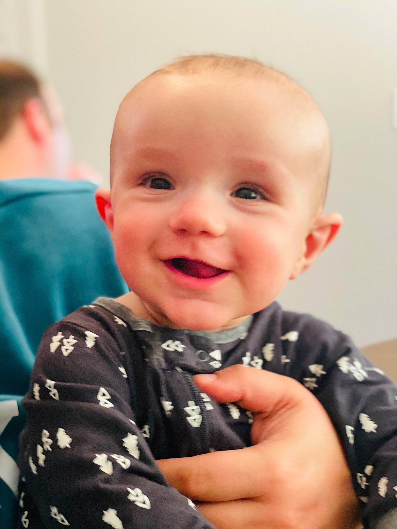 Santino is registered to the contest to win money with this photo: baby, baby_toddler_clothing, cheek, child, eye, finger, fun, gesture, hairstyle, hand, happy, human_body, iris, joy, person, sitting, skin, sleeve, smile, t_shirt