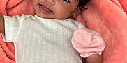 Nalani is registered to the contest to win money with this photo: baby, infant, smile, white_clothing, pink_mitten, blanket, soft_texture, lying_down, cute, happy, child, face, skin, hair, portrait, indoors, comfort, warm, young, adorable