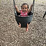 baby, child, cute, daylight, feet, fun, grass, hands, happy, infant, metal_chains, outdoor, person, pink_clothing, playground, seat, smiling, summer, swing, woodchips