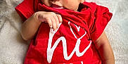 Nalani is registered to the contest to win money with this photo: baby, blanket, child, closeup, comfort, cute, hand, headband, indoors, infant, legs, newborn, peaceful, person, portrait, red_onesie, resting, skin, sleeping, soft_texture