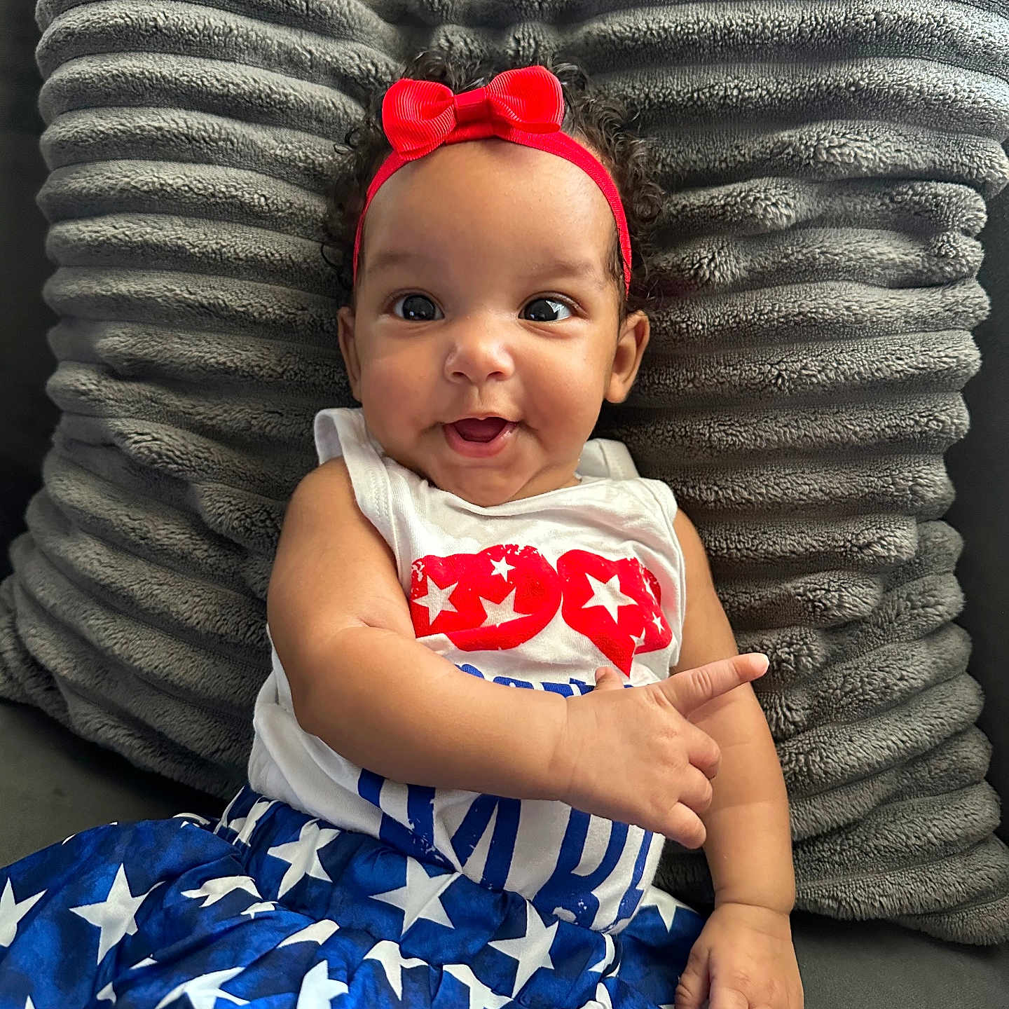 Nalani joined the competition — help win amazing prizes! baby, blue, child, clothing, couch, cute, dress, happy, headband, indoor, infant, person, pillow, plush, portrait, red, red_bow, smiling, stars, white