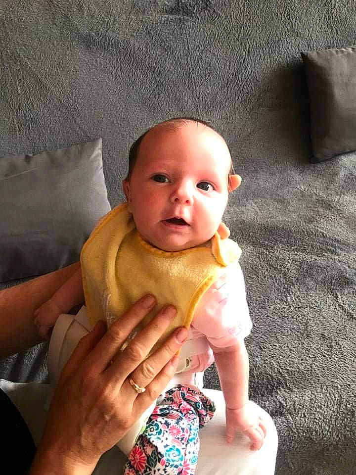 Charlène participe au concours pour gagner de l'argent avec cette photo : abdomen, baby, baby_toddler_clothing, chair, cheek, comfort, eye, face, finger, foot, head, human_leg, leg, linens, neck, person, skin, stomach, thumb, toddler