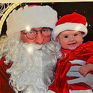 Emie-Rose participe au concours pour gagner de l'argent avec cette photo : baby, child, santa_claus, christmas, holiday, red_clothing, beard, glasses, hat, festive, smile, glove, portrait, celebration, happy, costume, person, face, winter, event