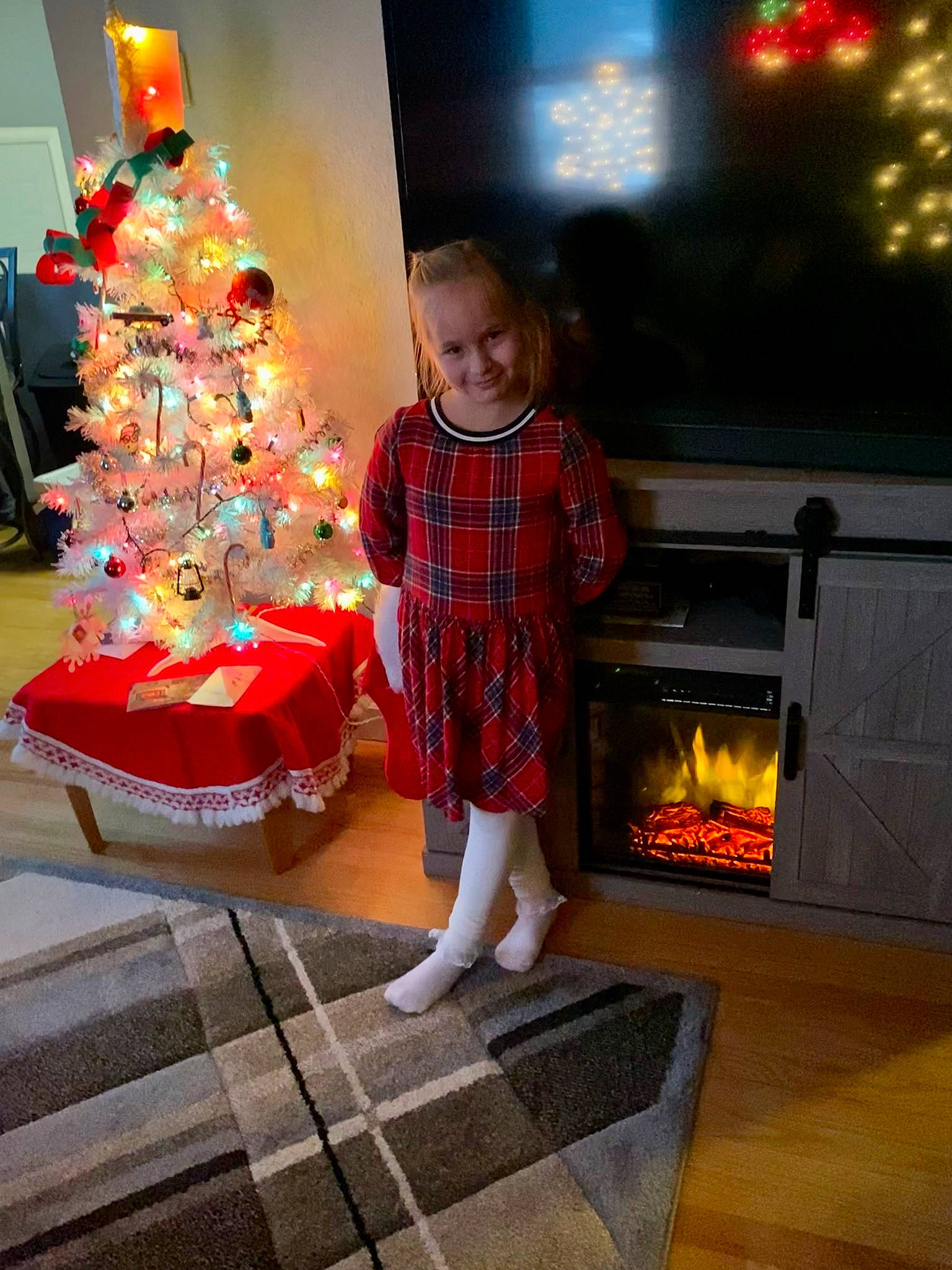 Alexis Marie is registered to the contest to win money with this photo: christmas, christmas_decoration, christmas_ornament, christmas_tree, dress, event, fireplace, flooring, fun, gas, heat, holiday, holiday_ornament, joy, lighting, living_room, ornament, person, room, toddler