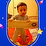 Adian is registered to the contest to win money with this photo: baby, child, toddler, standing, playpen, indoor, portrait, face, eyes, hair, curious, serious, clothing, room, carpet, toy, furniture, smartphone_screenshot, social_media, colorful