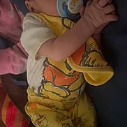 Easton is registered to the contest to win money with this photo: baby, sleeping, pacifier, hands_clasped, yellow_pajamas, winnie_the_pooh, blanket, cozy, infant, child, cute, resting, indoors, soft_lighting, portrait, person, clothing, footwear, sleep, peaceful