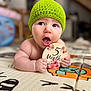 baby, infant, green_hat, play_mat, wooden_sign, 5_months, cute, child, indoor, portrait, expression, hand, face, skin, eyes, mouth_open, knitted, floor, colorful, young