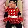 baby, infant, child, minnie_mouse, hat, costume, red_dress, polka_dots, tutu, black_leggings, yellow_booties, pink_cushion, blanket, cute, portrait, indoors, smiling, face, person, seated
