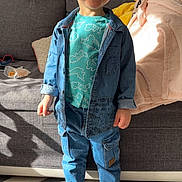 élyo participe au concours pour gagner de l'argent avec cette photo : toddler, child, smiling, denim_jacket, denim_pants, socks, living_room, couch, blanket, carpet, happy, indoor, person, clothing, casual, portrait, cute, young_child, standing, home
