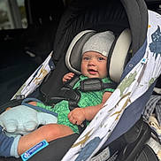 Philippe is registered to the contest to win money with this photo: baby, infant, car_seat, harness, beanie, green_romper, sock, plush_toy, buckle, vehicle_interior, window, bokeh, portrait, child, sitting, closeup, headrest, patterned_cover, chubby_cheeks, cute