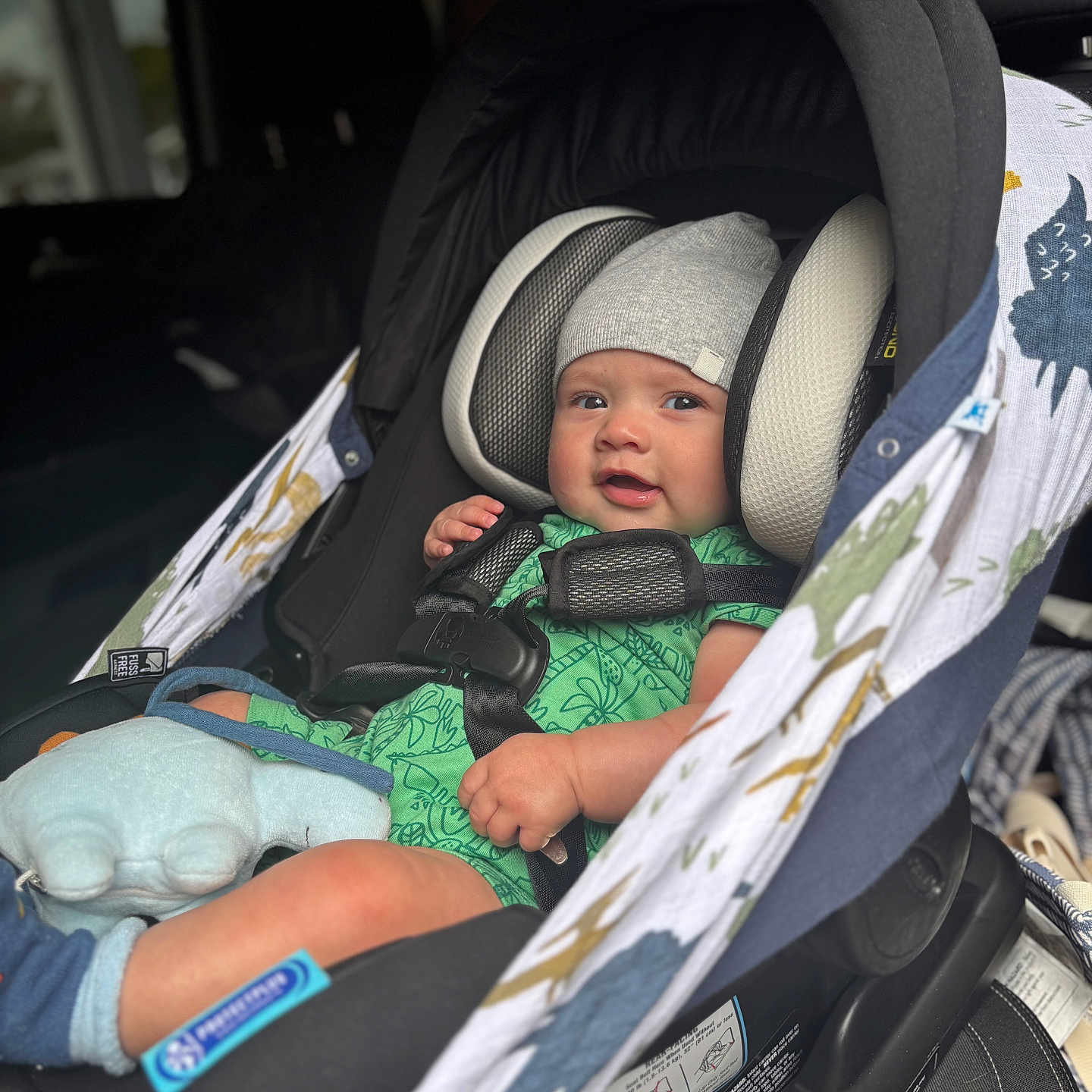Philippe is registered to the contest to win money with this photo: baby, beanie, bokeh, buckle, car_seat, child, chubby_cheeks, closeup, cute, green_romper, harness, headrest, infant, patterned_cover, plush_toy, portrait, sitting, sock, vehicle_interior, window