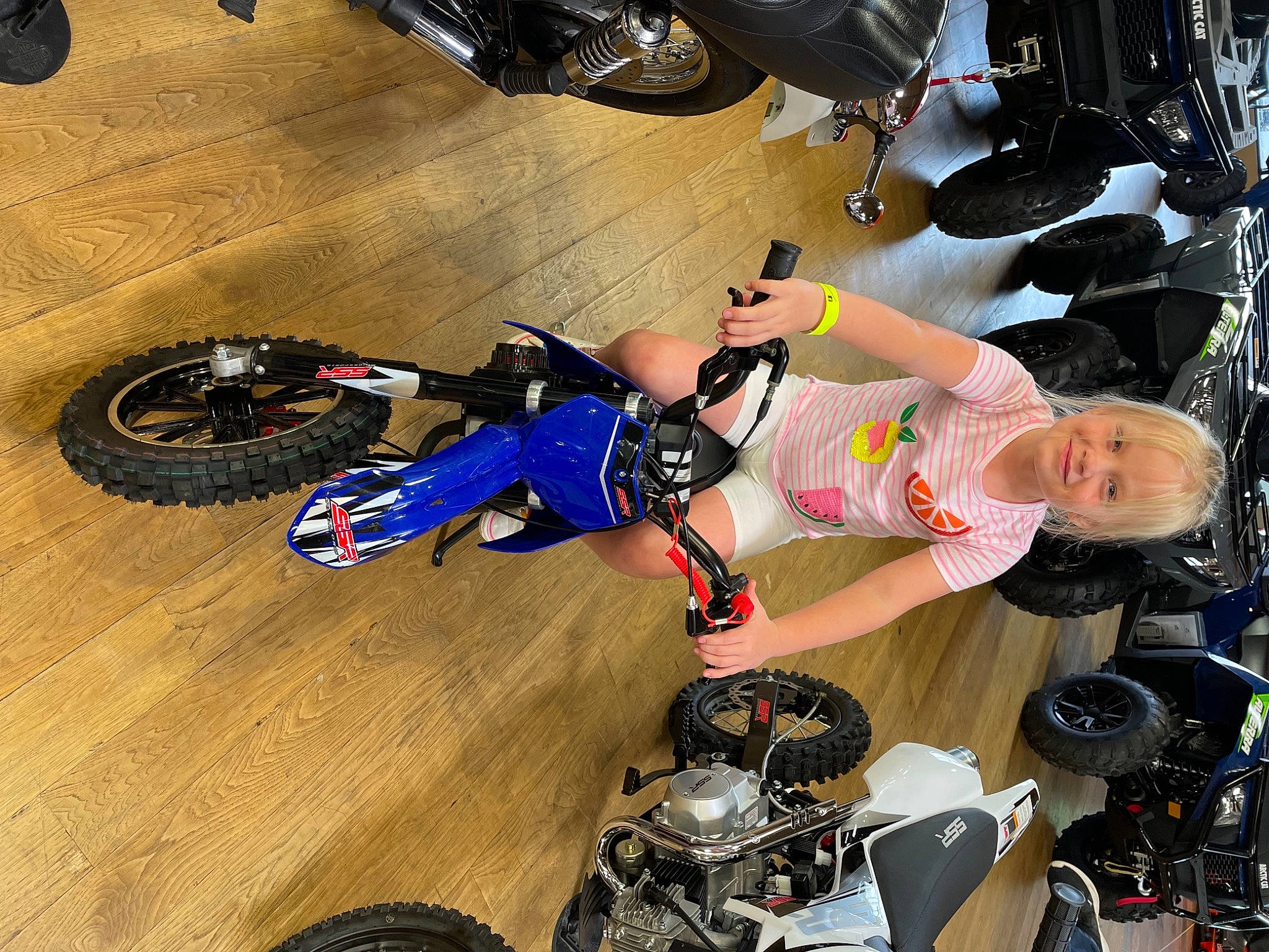 Maisey is registered to the contest to win money with this photo: automotive_design, automotive_exterior, automotive_lighting, automotive_tire, black, fender, joy, leg, light, motor_vehicle, motorcycle, motorcycle_accessories, person, rim, shoe, shorts, sneakers, thigh, tire, tread