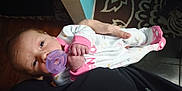 Bellefyre joined the competition — help win amazing prizes! baby, pacifier, infant, onesie, pink, hand, face, person, floor, carpet, cloth, sleepwear, child, newborn, cute, indoor, human, portrait, holding, soft