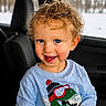 Mason joined the competition — help win amazing prizes! blue_eyes, car_interior, casual, child, clothing, curly_hair, cute, dinosaur, happy, indoor, person, playful, portrait, seat, smiling, snow, sweatshirt, toddler, window, winter