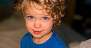 Mason is registered to the contest to win money with this photo: baby, blue_eyes, blue_shirt, casual_clothing, child, close_up, curly_hair, curly_hair_boy, cute, face, happy, headshot, indoor, person, portrait, sitting, skin, smiling, toddler, young_child