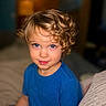 Mason is registered to the contest to win money with this photo: child, toddler, curly_hair, blue_eyes, blue_shirt, portrait, indoor, smiling, young_child, face, person, cute, happy, sitting, curly_hair_boy, casual_clothing, close_up, skin, headshot, baby