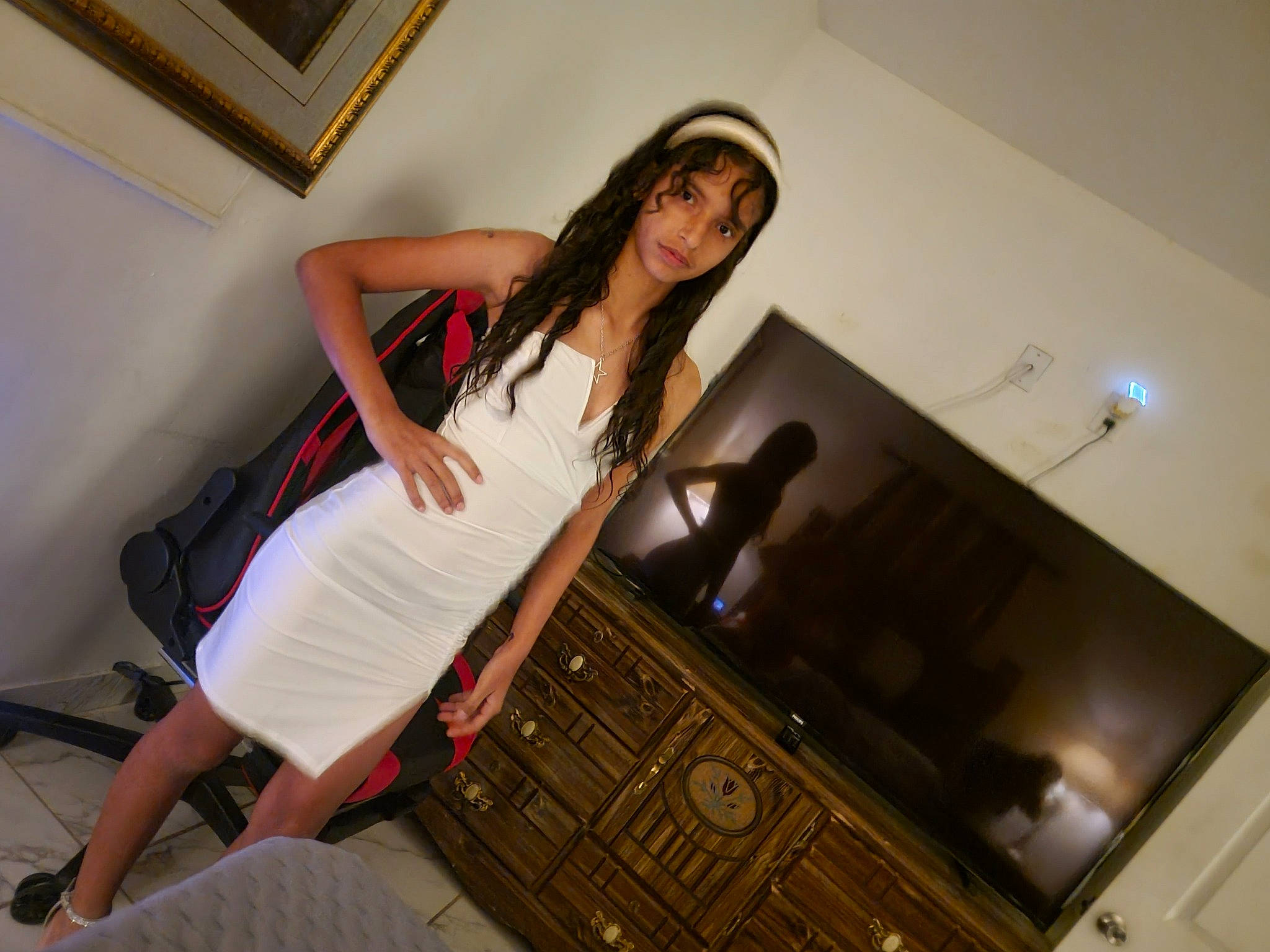 Anabella is registered to the contest to win money with this photo: black_hair, cabinetry, comfort, couch, drawer, fashion_design, flash_photography, floor, flooring, hardwood, human_leg, interior_design, knee, leg, living_room, long_hair, person, picture_frame, thigh, under_exposed