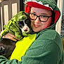 Oliver joined the competition — help win amazing prizes! person, dog, puppy, costume, dinosaur, green, glasses, indoor, cuddling, smiling, cute, pet, face, black_and_white_dog, plush, hoodie, nose_ring, home, holding, affection